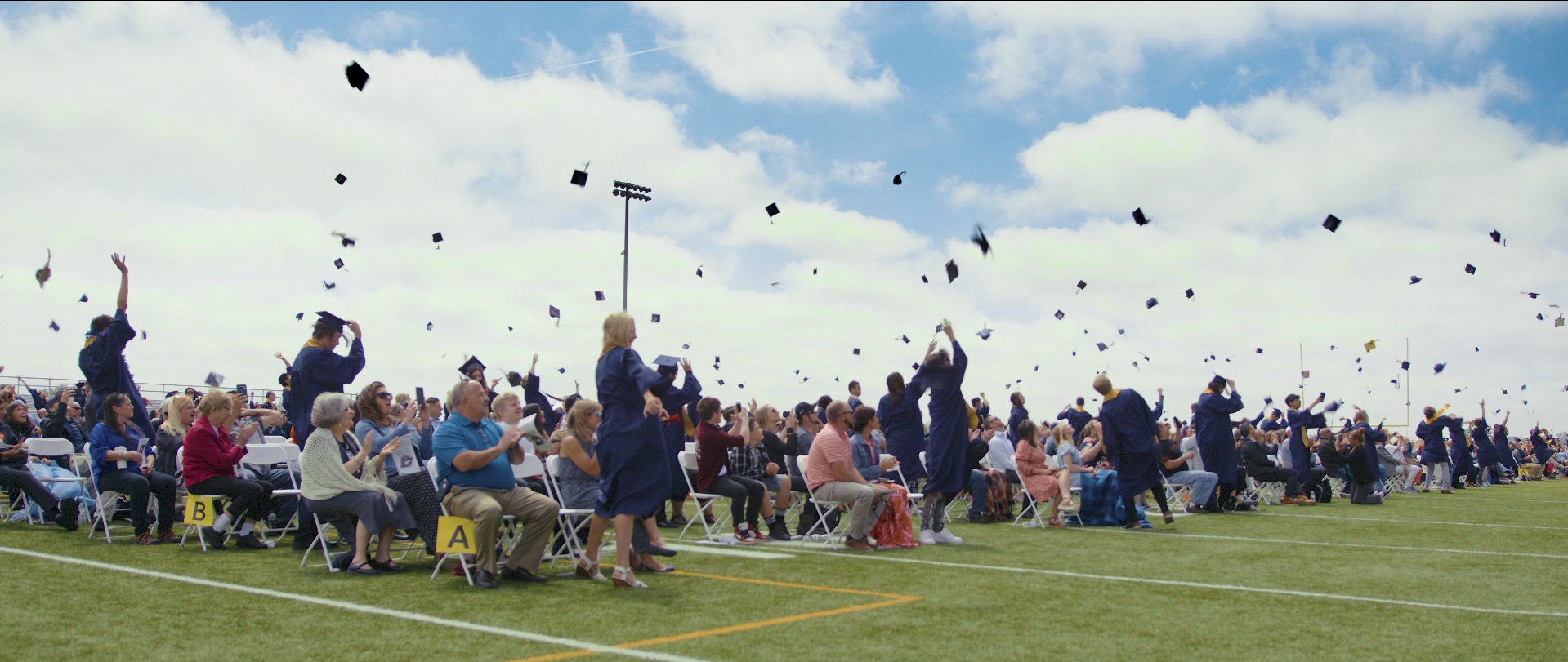 Graduados del Frederick High School lanzando sus birretes de graduación