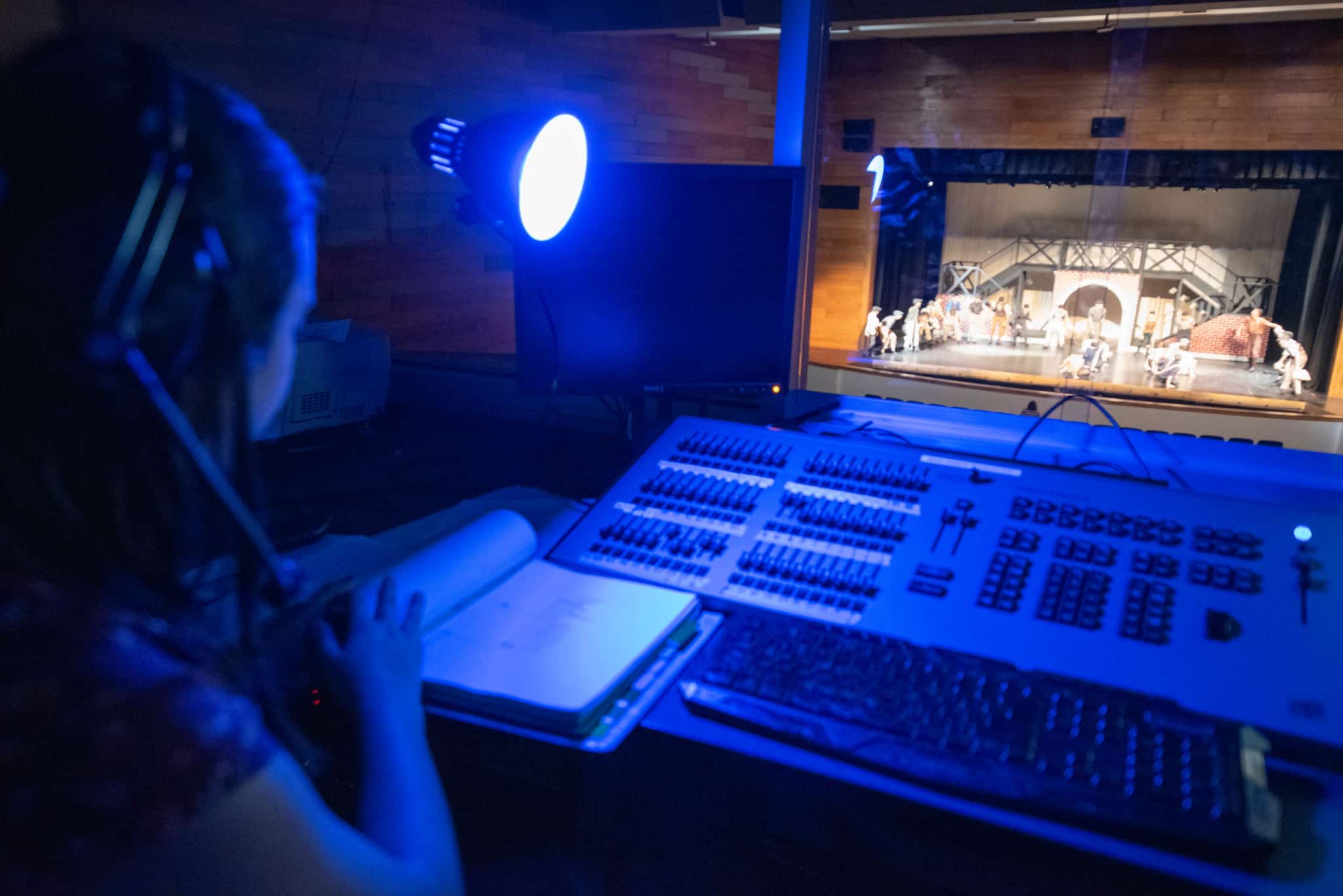 Theater student working in tech booth during high school musical